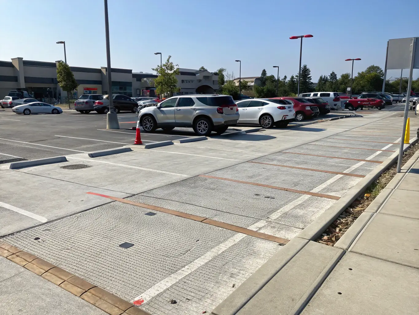 A large commercial parking lot with freshly poured concrete and clear markings, demonstrating Sandstone Concrete's commercial capabilities.